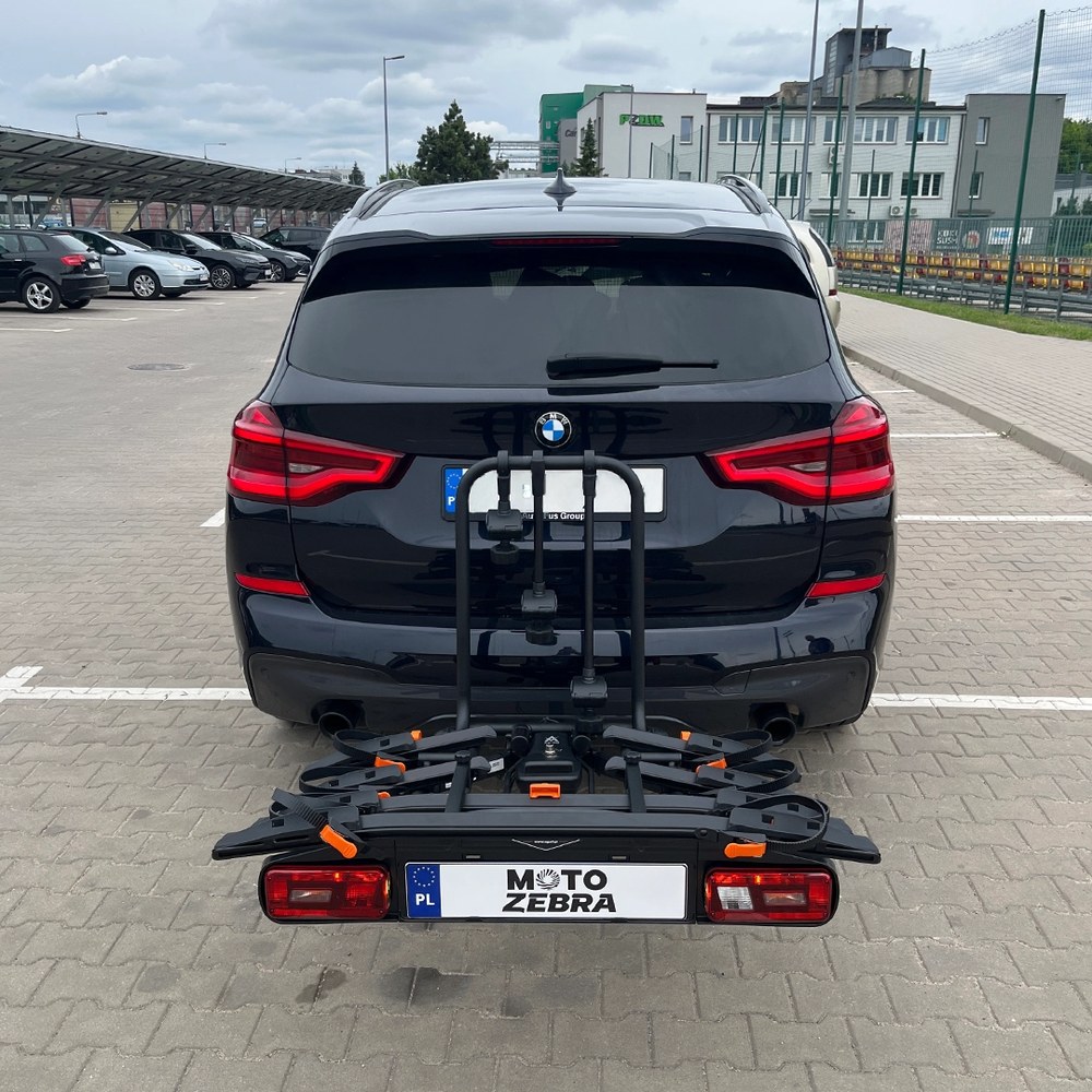 Aguri Active Bike PRO 4 czarny zamontowany na haku SUV-a, widok z tyłu na parkingu - Sklep motozebra