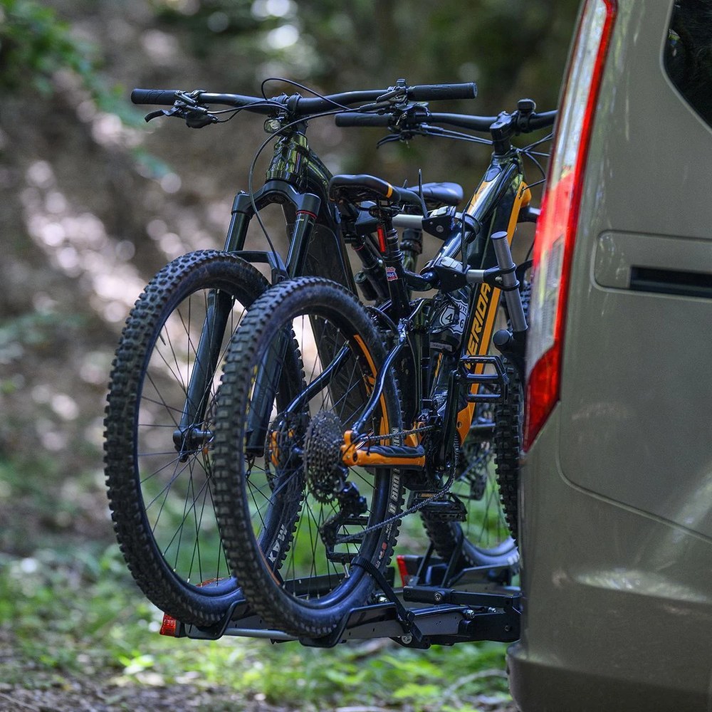 MENABO ORBIT 2 z rowerami na haku zielonego SUV-a w terenie leśnym - Sklep motozebra