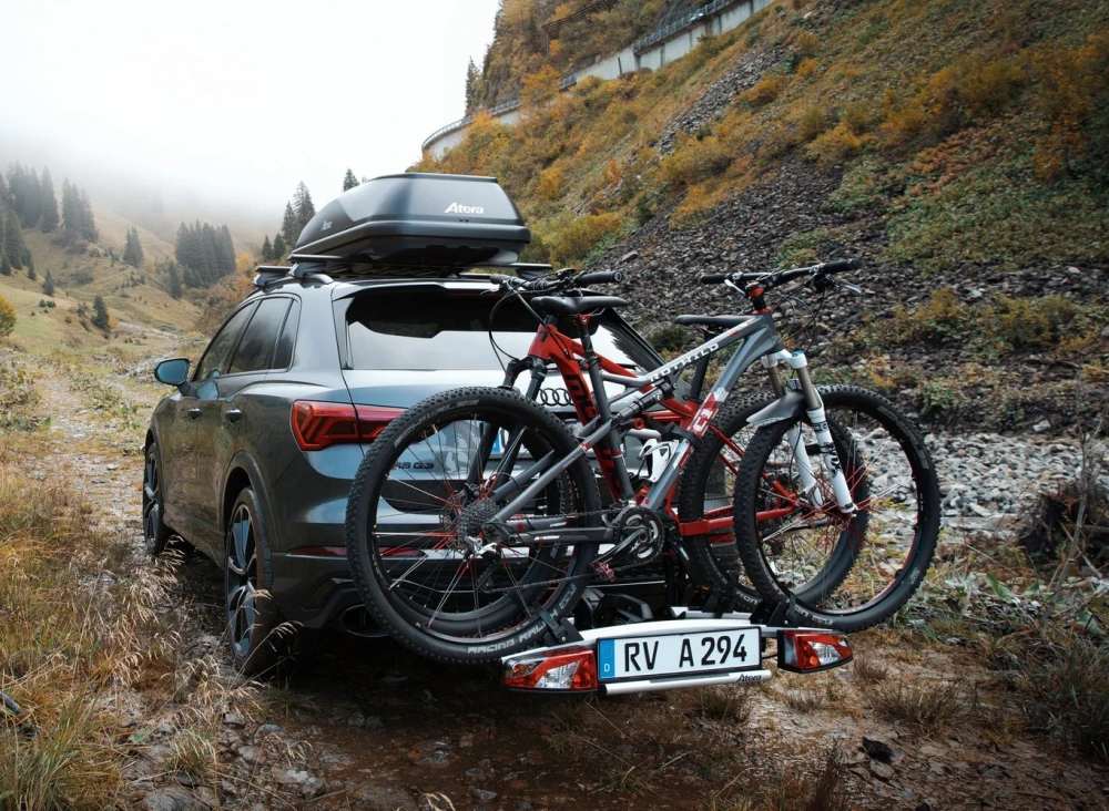 Dwa rowery zapięte na bagażniku Atera Strada Trail 2 z tyłu SUV-a w górach