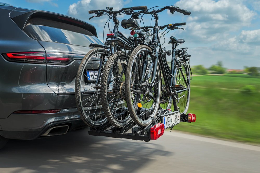Inter Pack Spider 3 Lite z trzema rowerami na haku SUV-a, widok z boku na drodze - Sklep motozebra